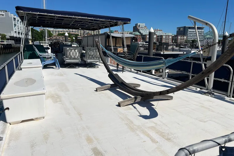 Slide: The Image of 1993 Sumerset houseboat deck with hammock, seating, and canopy in a marina setting. - 29