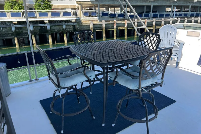Slide: The Image of Outdoor seating on 1993 Sumerset houseboat deck with metal chairs and table by the water. - 33