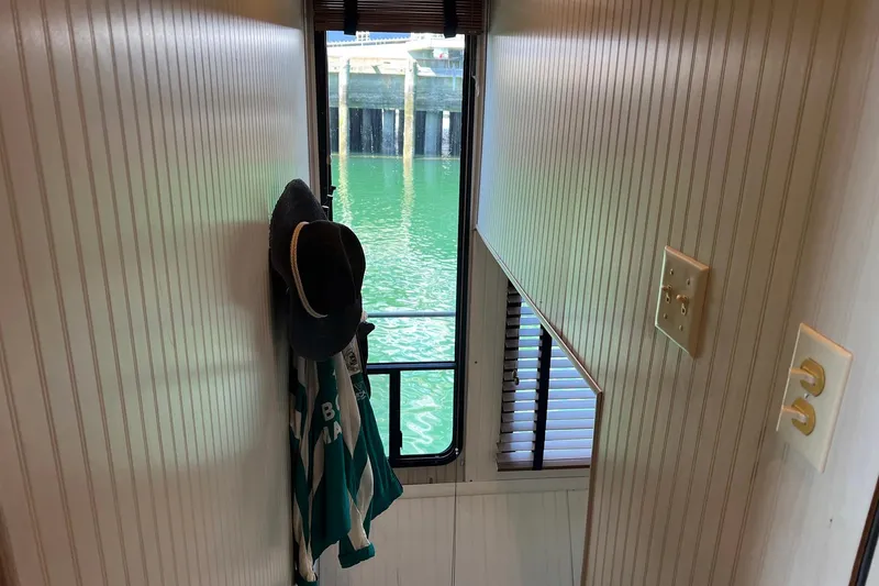 Slide: The Image of Narrow hallway inside a 1993 Sumerset houseboat with a view of the water. - 36