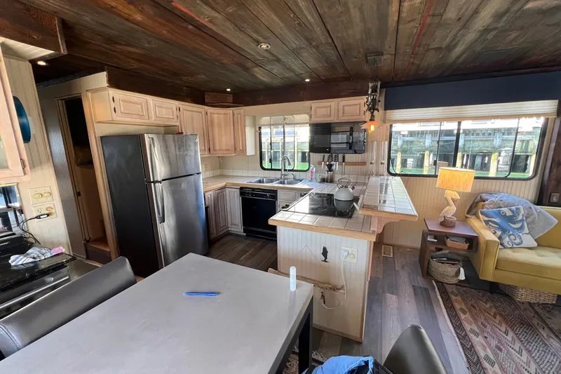 Slide: The Image of Interior of a 1993 Sumerset houseboat featuring a kitchen and cozy living area. - 9