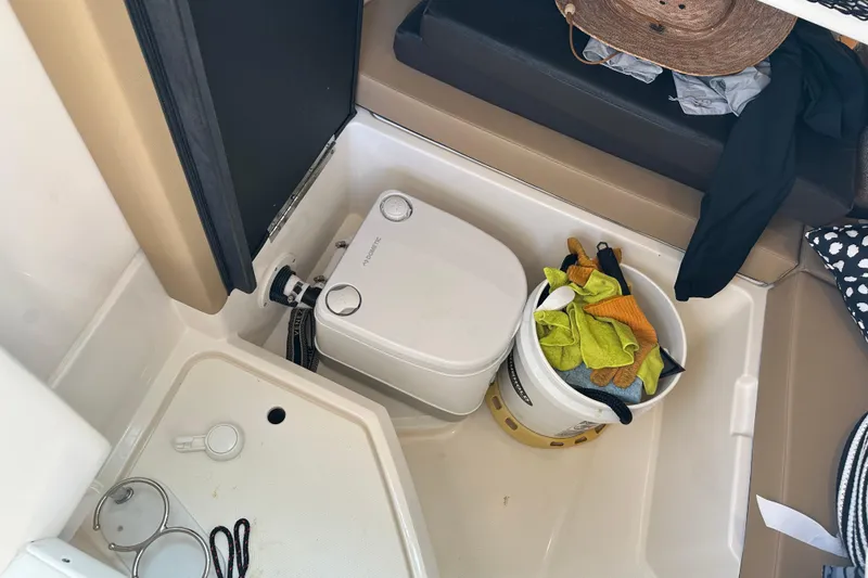 Slide: The Image of Interior of 2022 Sea Ray SLX 250 boat with storage area and cleaning supplies. - 46