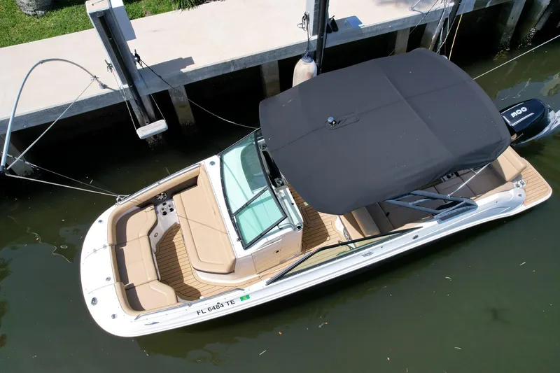 Slide: The Image of 2022 Sea Ray SLX 250 boat docked, featuring a sleek design and black canopy. - 9