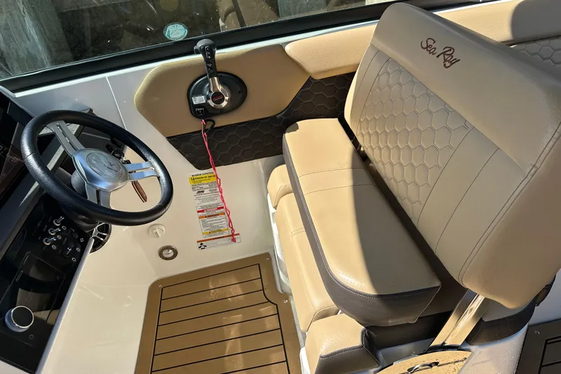 Slide: The Image of 2022 Sea Ray SLX 250 boat interior with steering wheel and beige seating. - 20