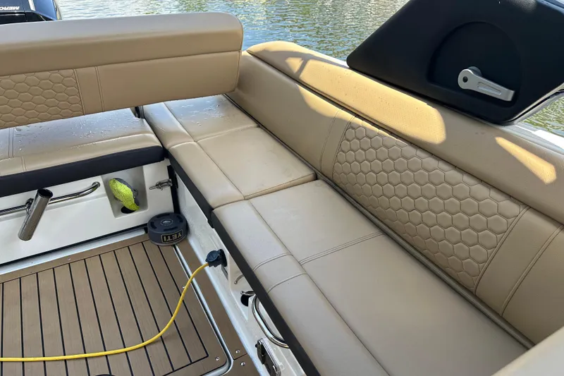 Slide: The Image of 2022 Sea Ray SLX 250 boat interior with beige seating and wooden flooring. - 27