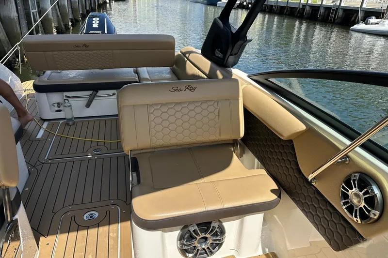 Slide: The Image of 2022 Sea Ray SLX 250 boat interior with tan seating and water view. - 24