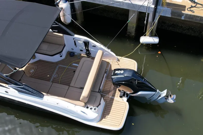 Slide: The Image of 2022 Sea Ray SLX 250 boat docked, featuring spacious seating and powerful outboard motor. - 10
