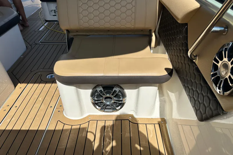 Slide: The Image of 2022 Sea Ray SLX 250 boat interior with tan seating and wood-patterned flooring. - 28