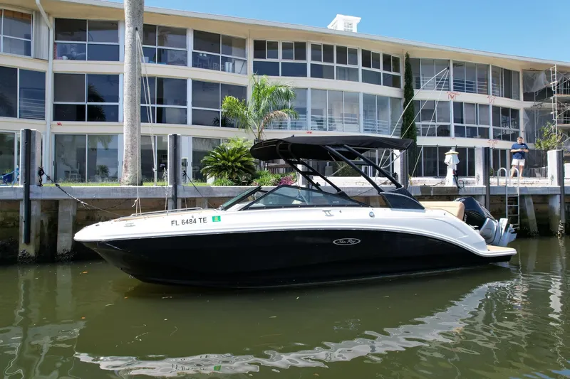 Slide: The Image of 2022 Sea Ray SLX 250 boat docked by waterfront apartments. - 51