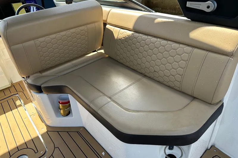 Slide: The Image of 2022 Sea Ray SLX 250 boat interior with beige leather seating and hexagonal stitching. - 29