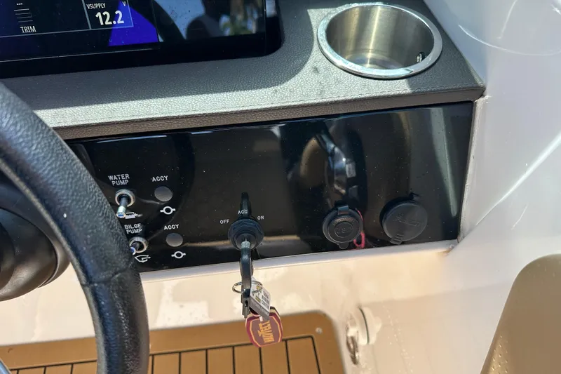 Slide: The Image of Control panel of 2022 Sea Ray SLX 250 boat with key ignition and switches. - 22