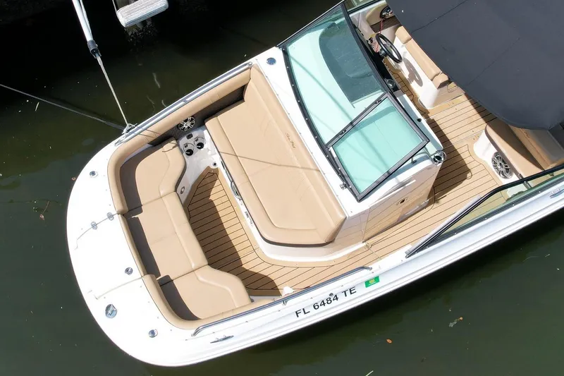 Slide: The Image of 2022 Sea Ray SLX 250 boat with tan seating and sleek design, docked in water. - 6