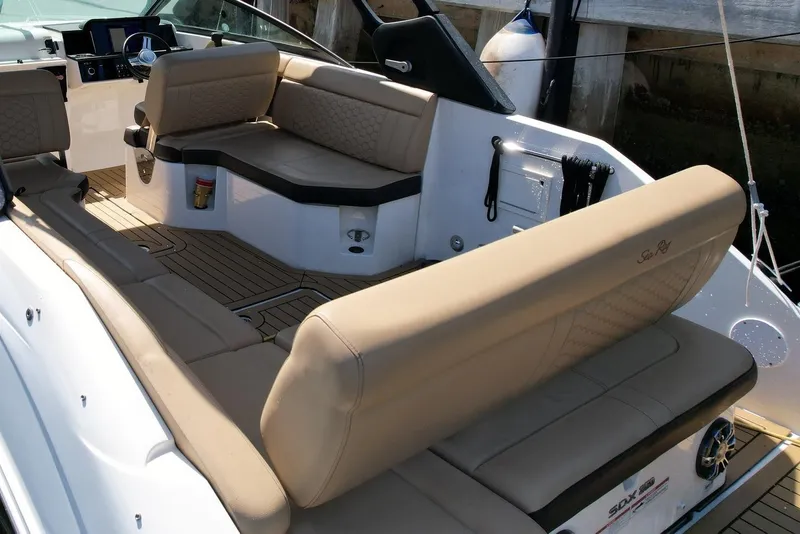 Slide: The Image of 2022 Sea Ray SLX 250 boat interior with beige seating and modern dashboard. - 8