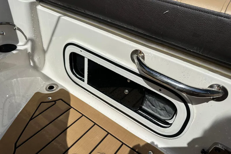 Slide: The Image of 2022 Sea Ray SLX 250 boat interior with storage compartment and stainless steel handle. - 34