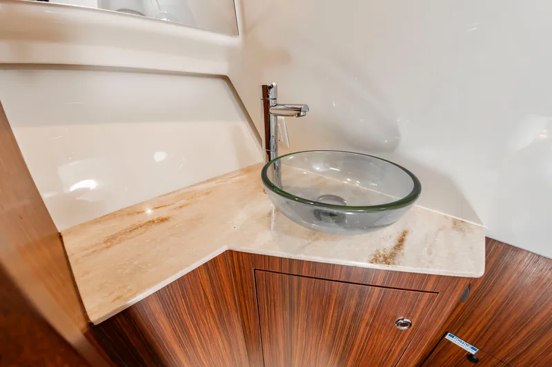 Slide: The Image of A sleek bathroom with a glass sink and wood paneling on a yacht. - 46