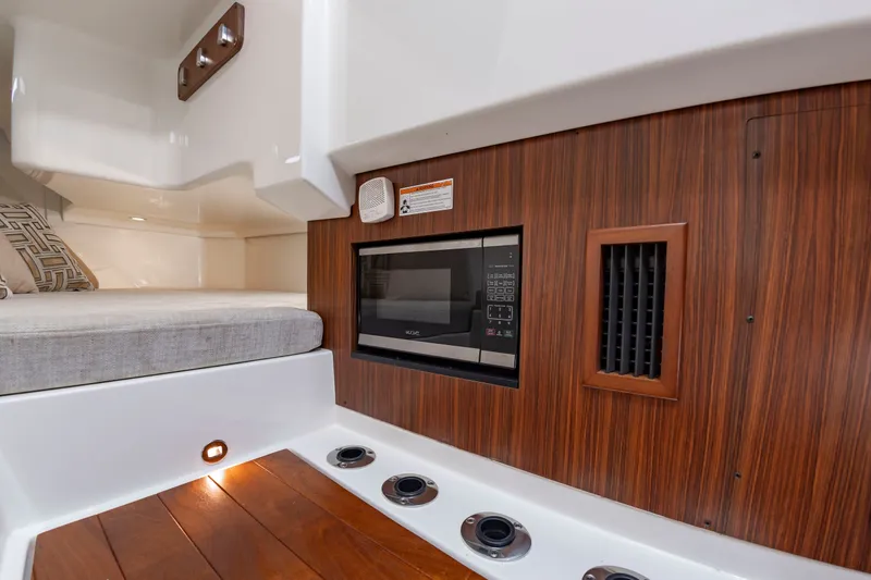 Slide: The Image of Interior of a 2021 Pursuit DC 365 Dual Console with a microwave and wooden flooring. - 39