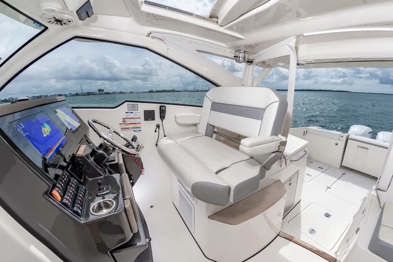 Slide: The Image of The image shows the cockpit of a 2021 Pursuit DC 365 Dual Console with a modern helm and comfortable seating. - 28