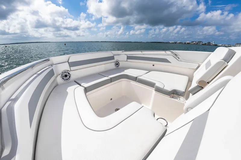 Slide: The Image of The 2021 Pursuit DC 365 Dual Console features a spacious, cushioned seating area overlooking the water. - 30