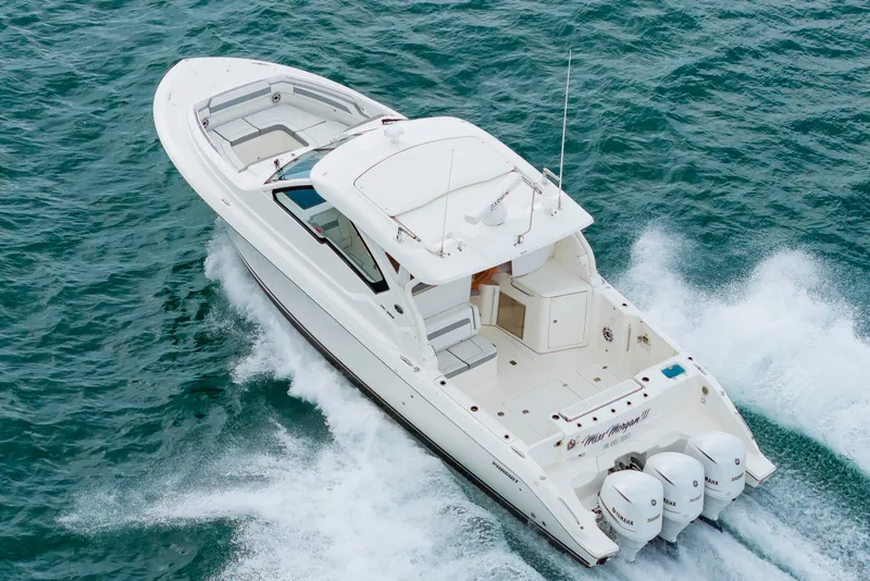 Slide: The Image of A white 2021 Pursuit DC 365 Dual Console boat speeding across the water. - 6