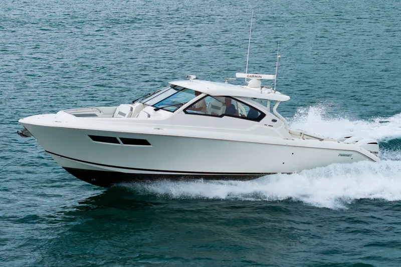 The Image of A white 2021 Pursuit DC 365 Dual Console boat speeding across the water. - 0