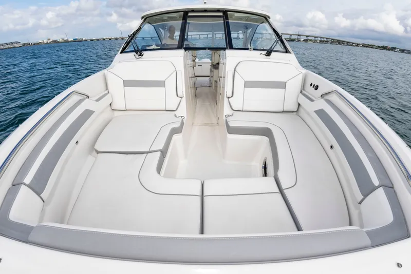 Slide: The Image of The 2021 Pursuit DC 365 Dual Console features a spacious, sleek deck with white upholstery. - 31