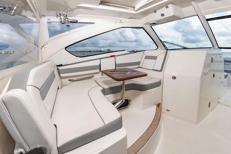 Slide: The Image of Interior of a 2021 Pursuit DC 365 Dual Console with elegant seating area and table. - 29