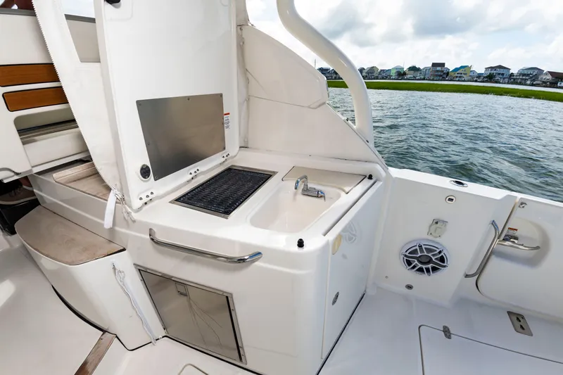 Slide: The Image of The 2021 Pursuit DC 365 Dual Console features an outdoor kitchen with sink and grill by the water. - 19
