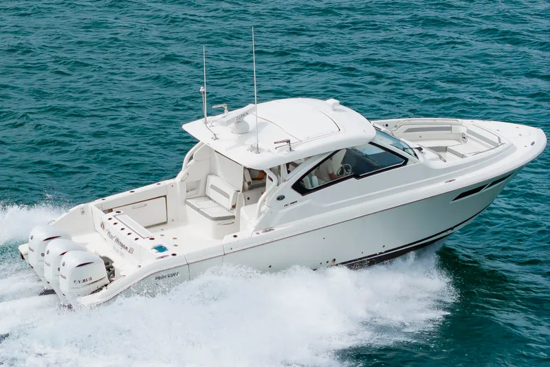 Slide: The Image of A white 2021 Pursuit DC 365 Dual Console boat speeds across the blue water. - 7