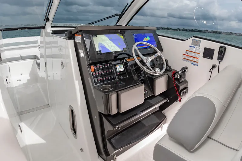 Slide: The Image of The image shows the cockpit of a 2021 Pursuit DC 365 Dual Console boat with modern navigation systems. - 26