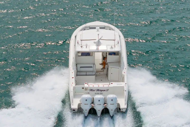 Slide: The Image of A white boat speeding across the water, featuring three outboard engines and an open deck. - 3