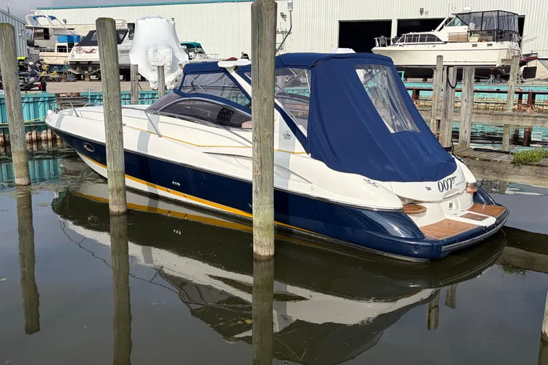Slide: The Image of Sunseeker Superhawk 34, 2000 model, docked in a marina with blue cover. - 2