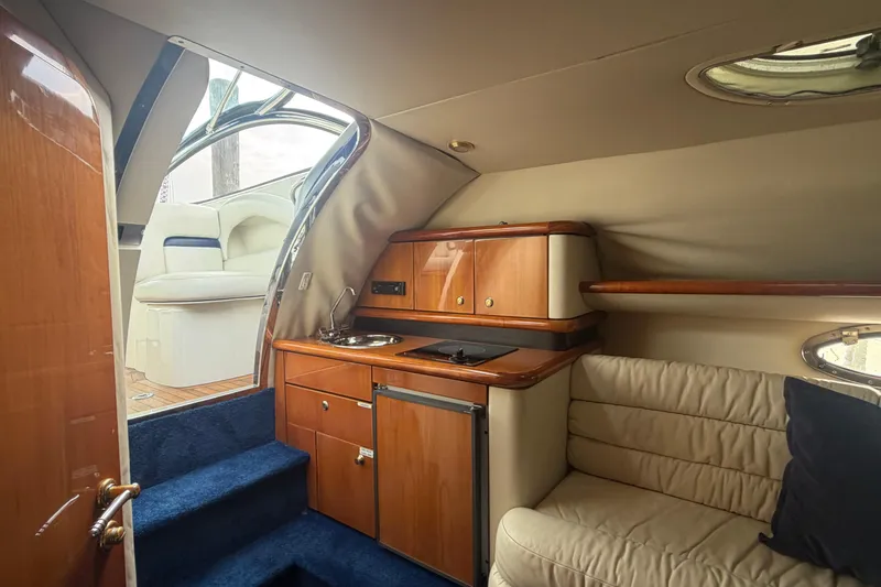Slide: The Image of Interior of 2000 Sunseeker Superhawk 34 yacht with kitchenette and seating area. - 25