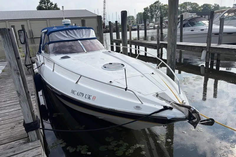 Slide: The Image of Sunseeker Superhawk 34, 2000 model, docked at a marina with surrounding boats. - 3