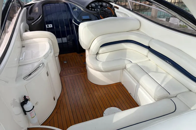 Slide: The Image of Interior of 2000 Sunseeker Superhawk 34 yacht with white seating and wooden flooring. - 6