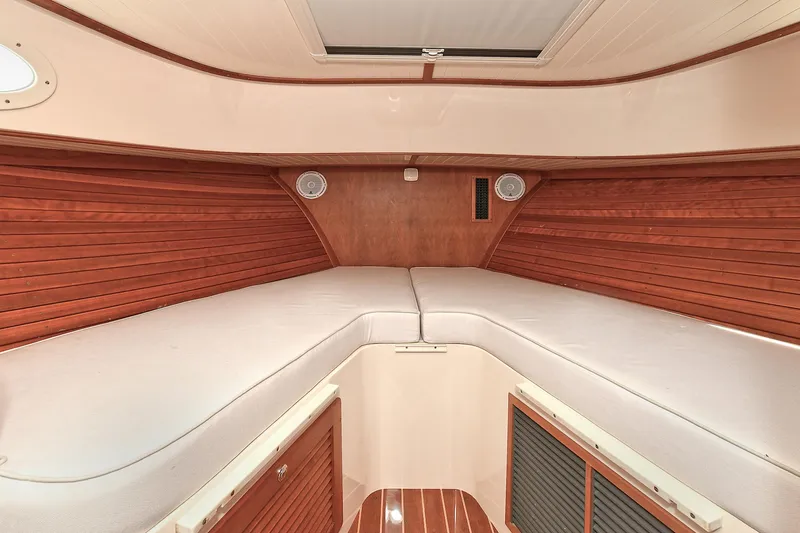 Slide: The Image of 2015 Hinckley Talaria 34 interior cabin with wooden paneling and cushioned seating. - 23