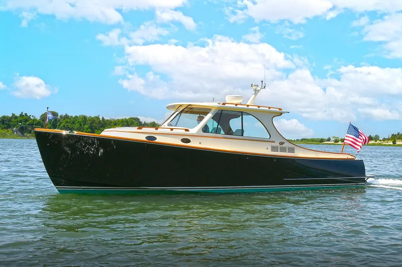 Slide: The Image of 2015 Hinckley Talaria 34 cruising on a sunny day with an American flag. - 2