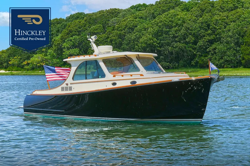 The Image of 2015 Hinckley Talaria 34 yacht on water, certified pre-owned, with American flag. - 0