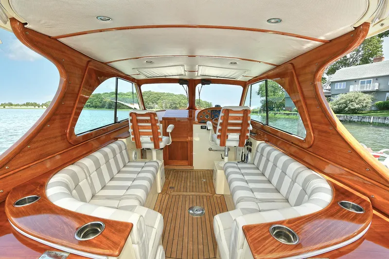 Slide: The Image of Luxurious 2015 Hinckley Talaria 34 yacht interior with elegant wood finish and striped seating. - 12