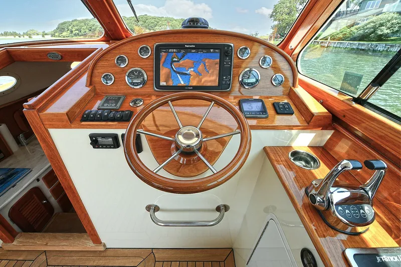 Slide: The Image of Helm of 2015 Hinckley Talaria 34 boat with wooden dashboard and navigation system. - 6