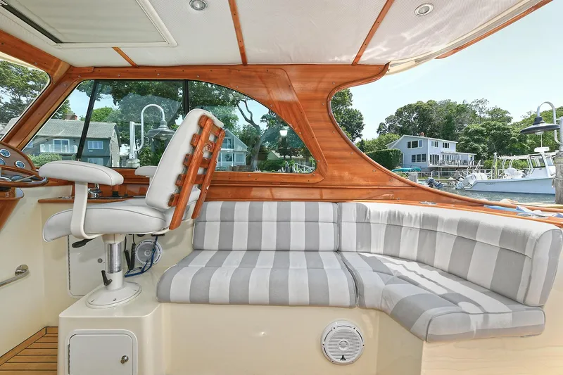 Slide: The Image of Interior of 2015 Hinckley Talaria 34 yacht with striped seating and wooden accents. - 10