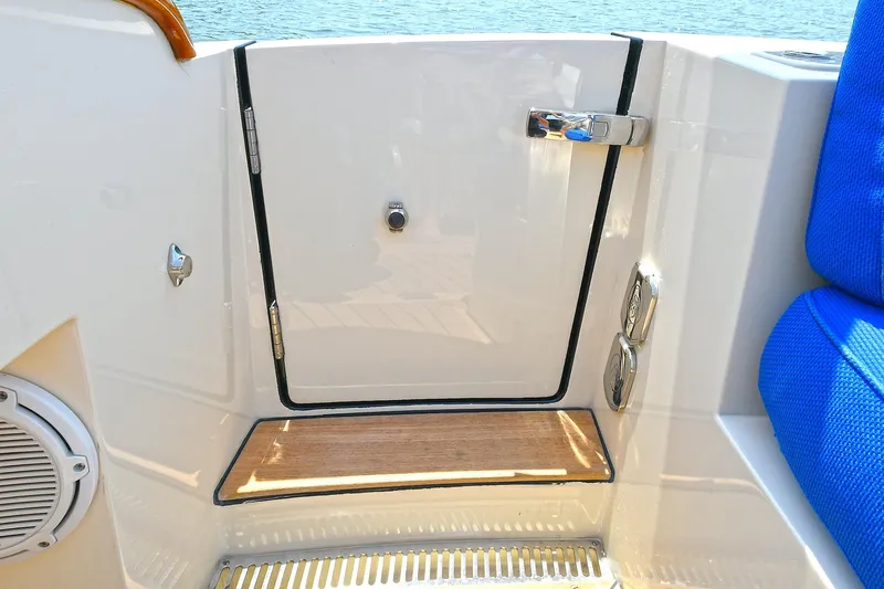 Slide: The Image of 2015 Hinckley Talaria 34 boat interior with blue seating and sleek white paneling. - 19