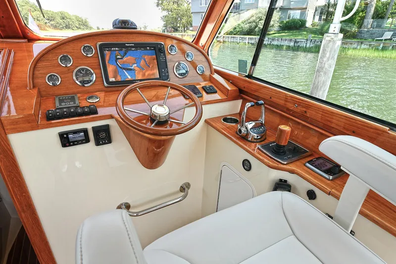 Slide: The Image of Helm of 2015 Hinckley Talaria 34 boat with wooden dashboard and navigation system. - 5