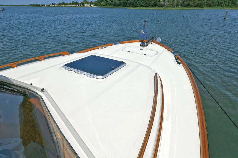 Slide: The Image of Hinckley Talaria 34 boat deck, 2015 model, cruising on calm waters with scenic shoreline. - 30