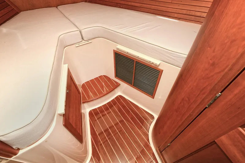 Slide: The Image of 2015 Hinckley Talaria 34 cabin interior with wooden flooring and cozy bedding. - 24