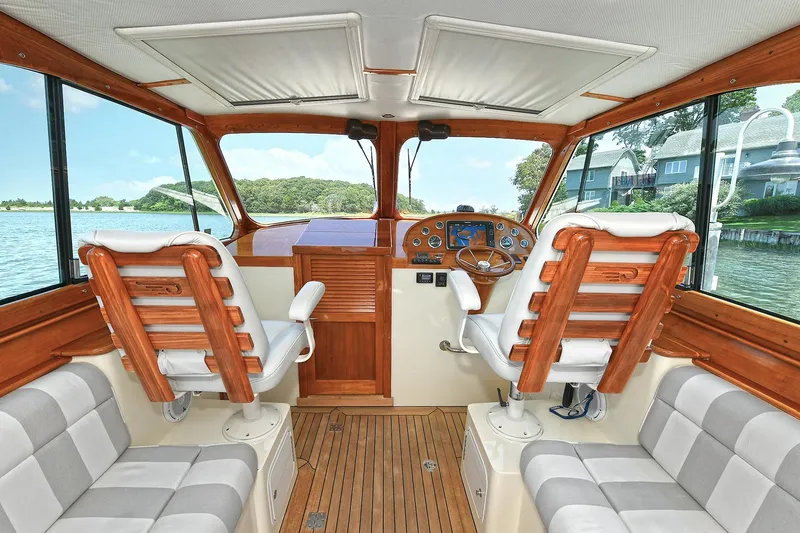 Slide: The Image of Interior of 2015 Hinckley Talaria 34 boat with wooden helm and plush seating. - 9