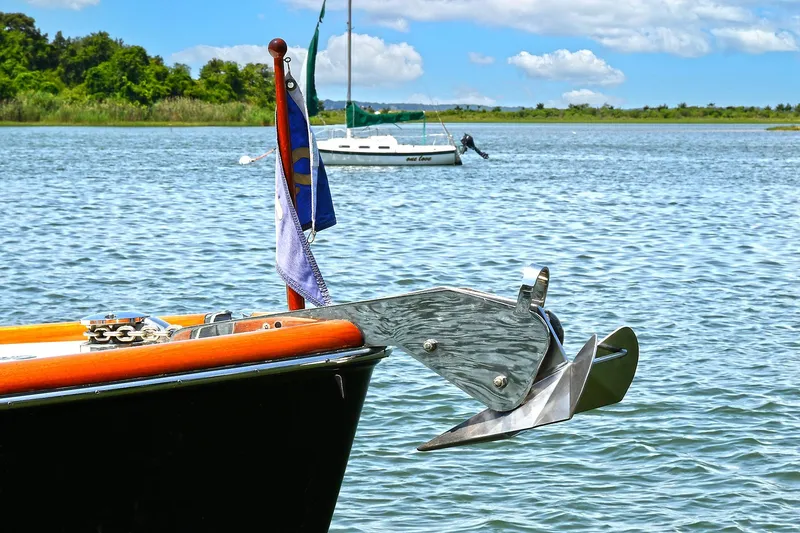 Slide: The Image of Hinckley Talaria 34 boat anchor and flag on calm water, 2015 model. - 29