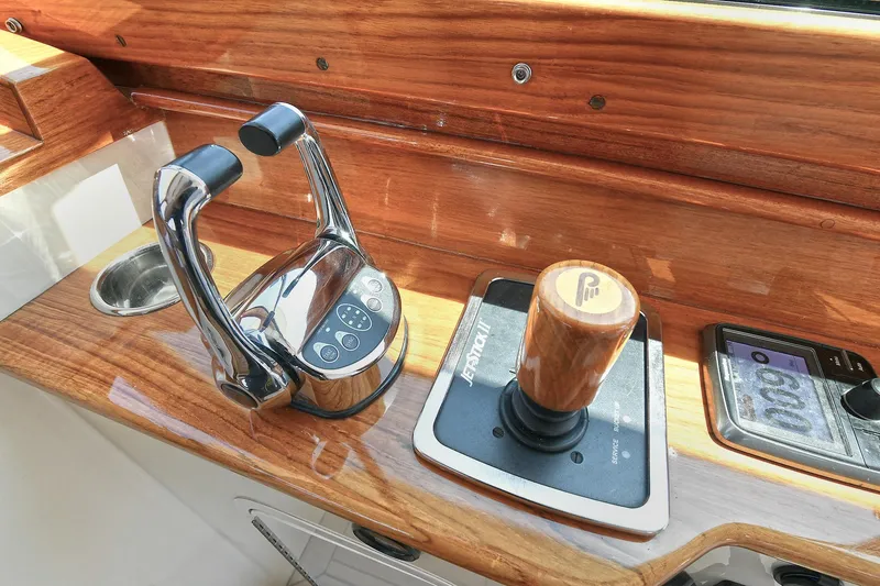 Slide: The Image of Hinckley Talaria 34 helm controls, featuring polished wood and chrome accents, 2015 model. - 7