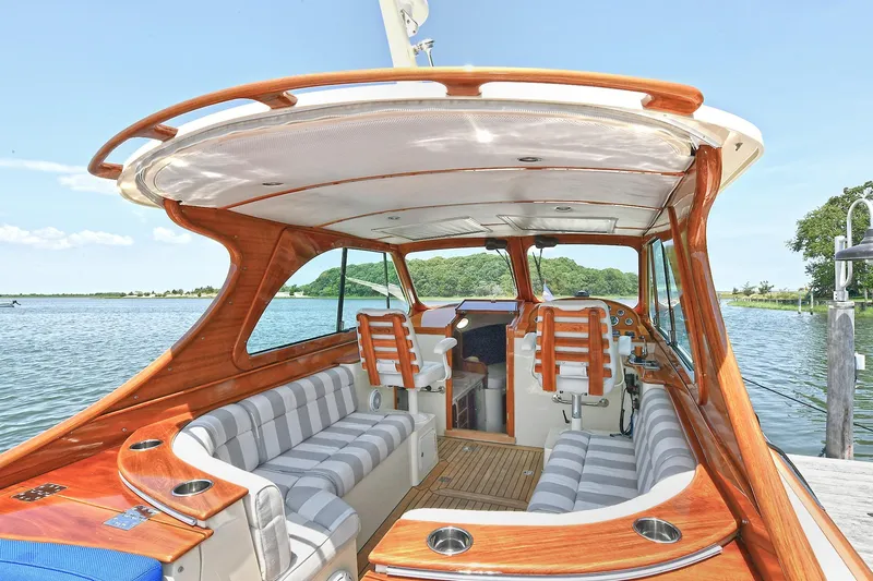 Slide: The Image of Luxurious 2015 Hinckley Talaria 34 yacht interior with elegant wood finish and striped seating. - 16