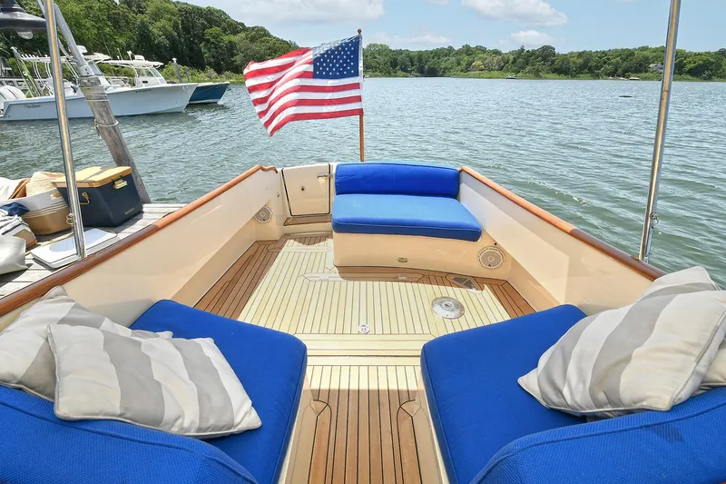 Slide: The Image of Hinckley Talaria 34 boat interior with blue cushions and American flag, 2015 model. - 18
