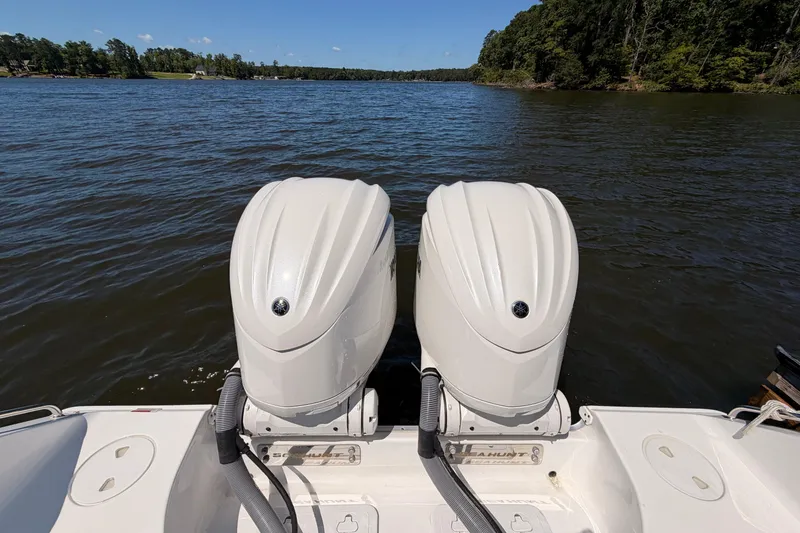 Slide: The Image of 2024 Sea Hunt Gamefish 27 Coffin Box with dual outboard motors on a lake. - 11