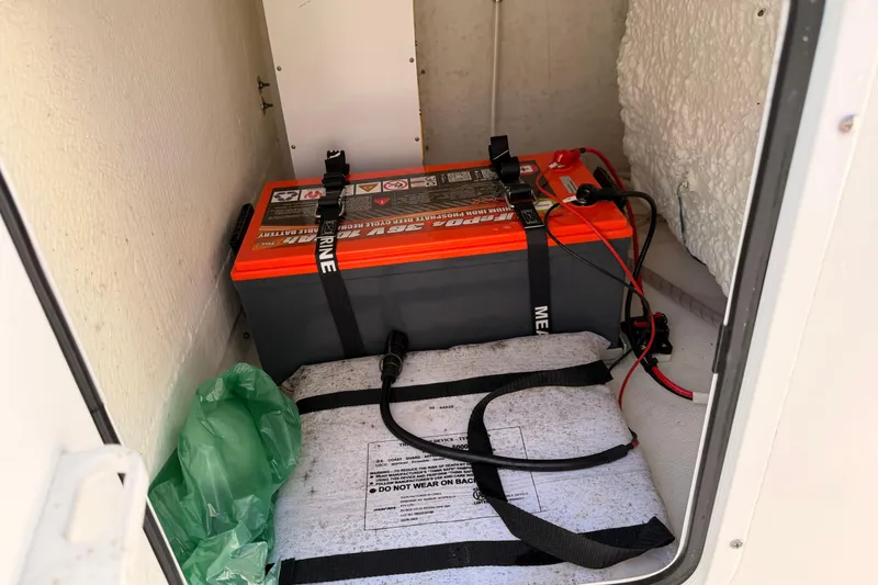 Slide: The Image of 2024 Sea Hunt Gamefish 27 Coffin Box battery compartment with secured marine battery. - 14